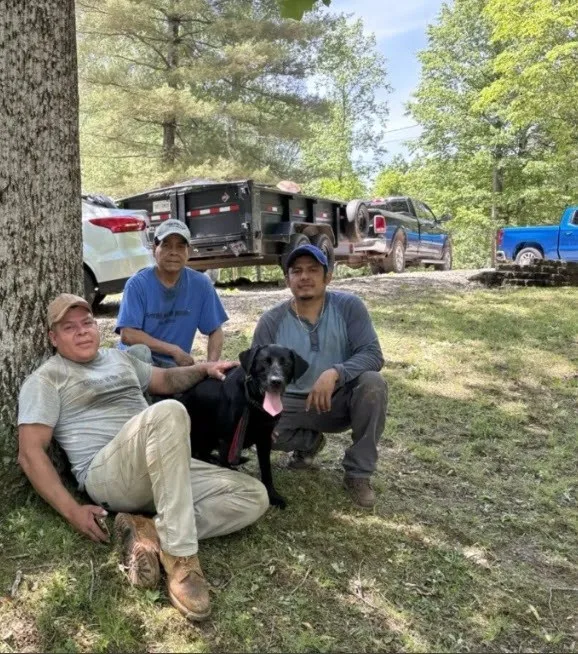 Brown County Stump Grinding crew and the shop dog taking a break beside the dump trailer after a job in Brown County, Indiana